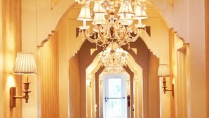 A grand hallway with a chandelier, wall sconces, and an arched ceiling. - The Riverview Hotel (New Smyrna Beach)