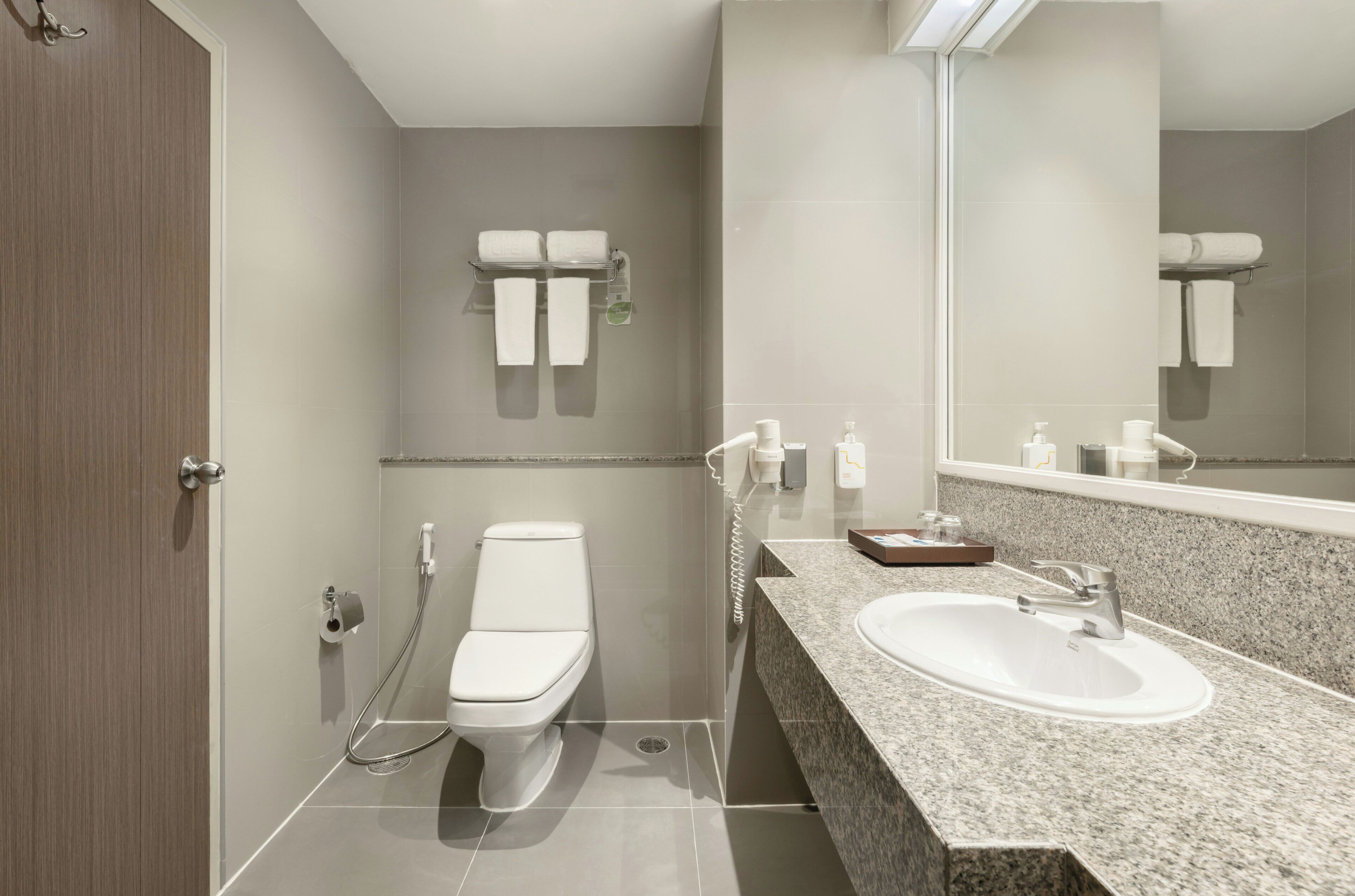A modern bathroom with a toilet, sink, and towel rack.