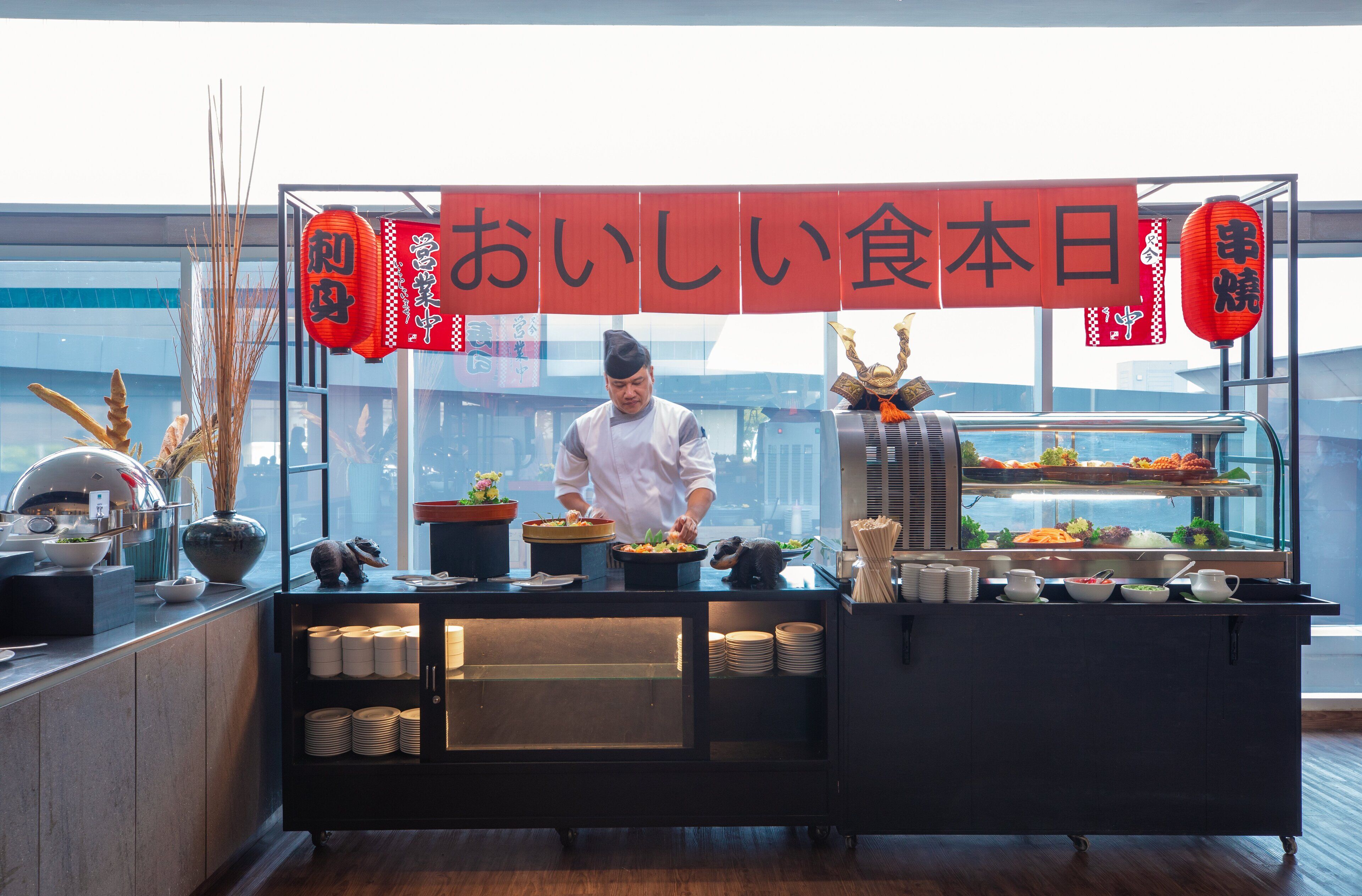A chef preparing food in a modern kitchen with a view of the city.