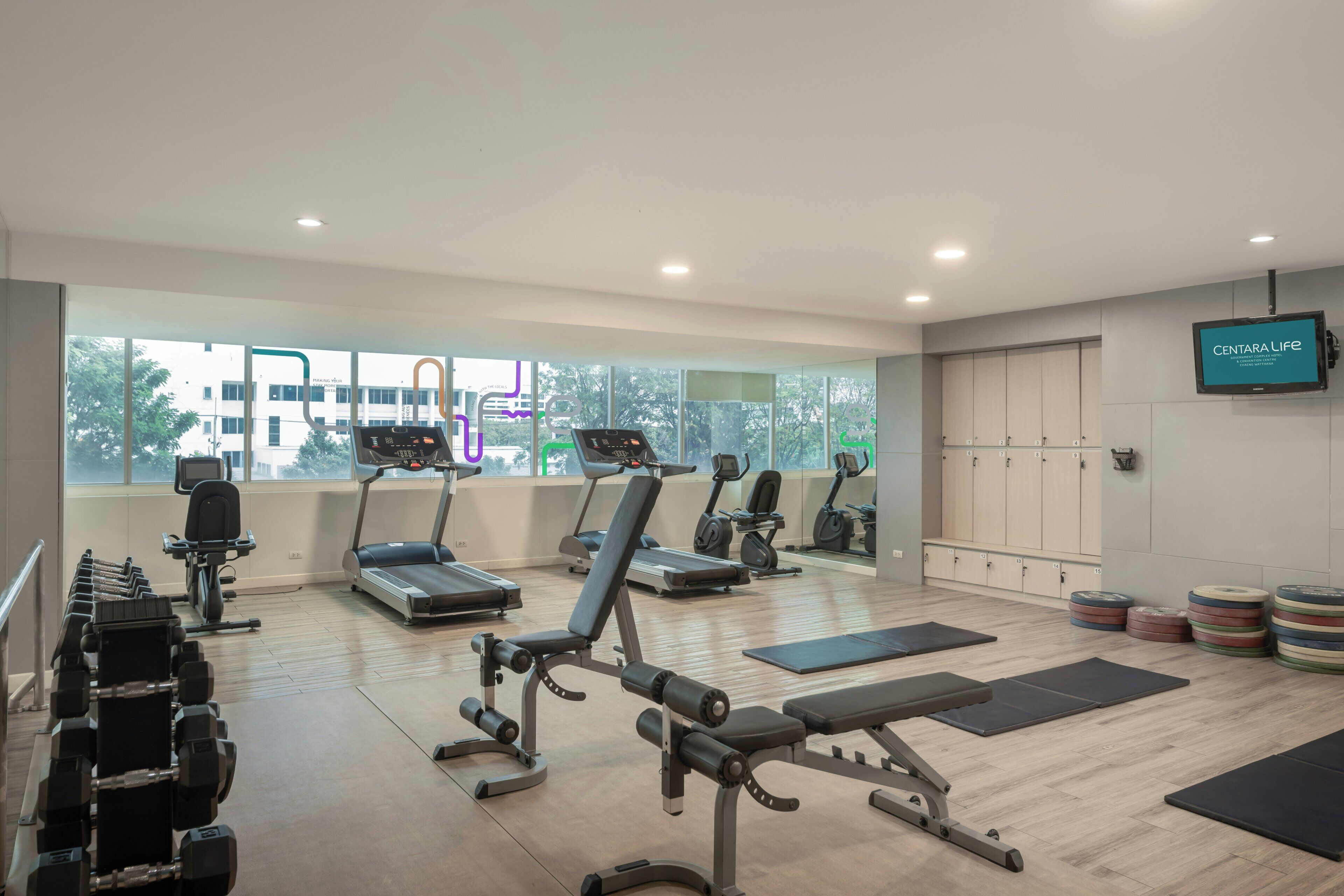 A gym with treadmills, weight machines, and exercise mats.