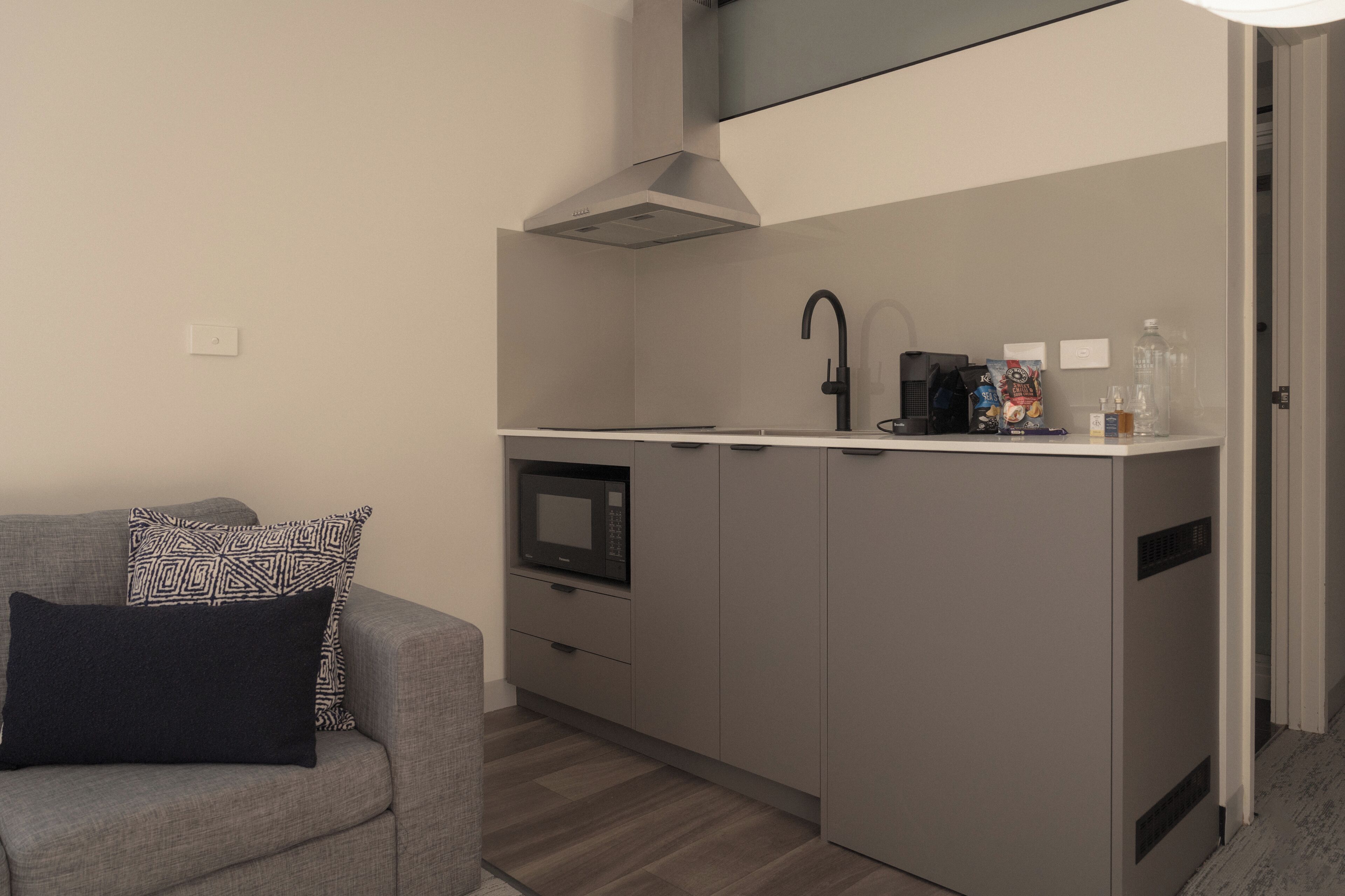 A compact kitchenette with a microwave, coffee maker, and a small countertop.