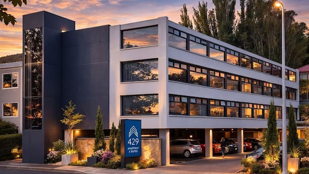 Un edificio moderno de varios pisos con un cartel que indica que son apartamentos y suites número 429.