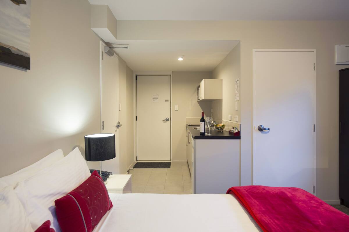 Ein Hotelzimmer mit Bett, Schreibtisch und einer Küchenzeile.