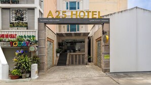 A hotel entrance with a sign reading "A25 HOTEL" and a staircase leading up to the entrance.