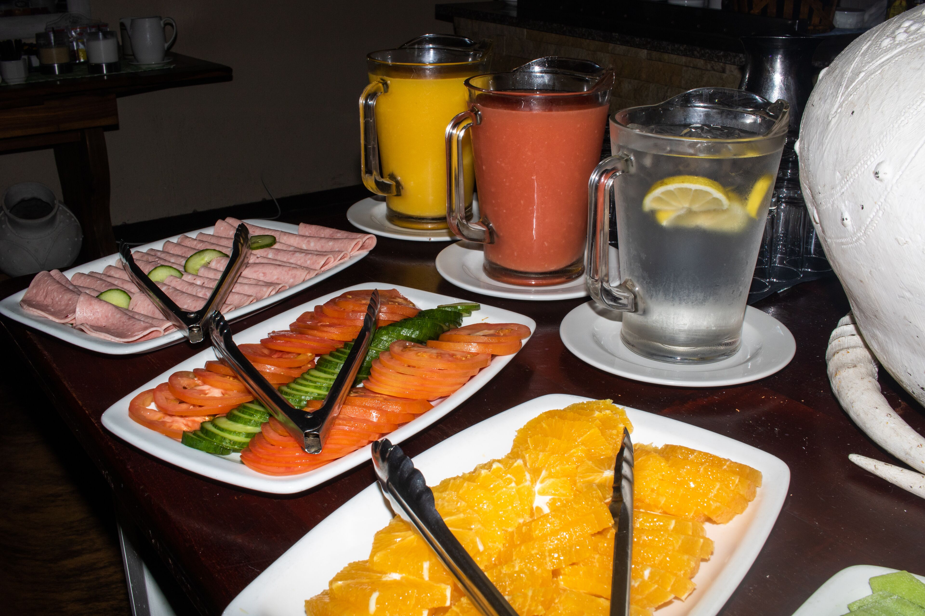 A buffet table with various food items and drinks.