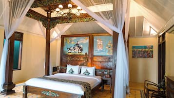 Een klassieke kamer met een hemelbed, een kroonluchter en een muurschildering.
