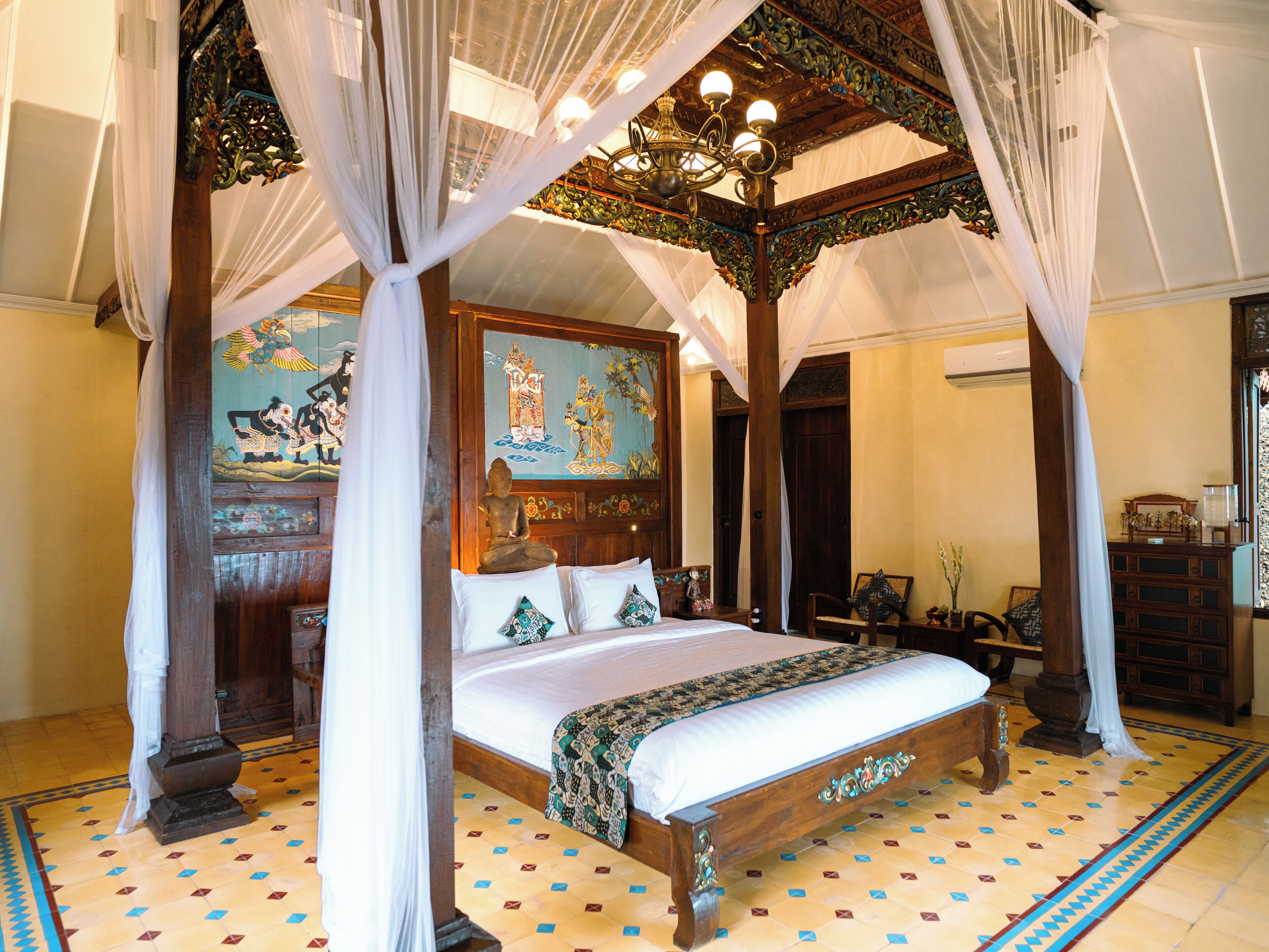 Una habitación tradicional con cama con dosel, un mural y suelo estampado.
