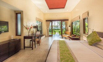 Habitación de hotel con cama, escritorio, televisión y vistas al exterior.