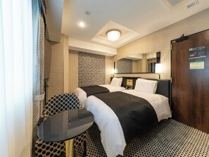 A hotel room with two beds, a small table, a chair, a mirror, and a door with an emergency exit sign. - APA Hotel Shibuya Dogenzakaue (Tokyo)