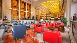 Un hall d’entrée spacieux avec un plafond haut, un bar et des espaces de détente confortables.