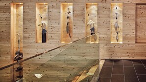 A wooden interior with a glass staircase and illuminated display cases containing various objects. - Hotel Traube (Pfunds)