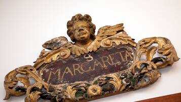 Una targa decorativa con il nome "MARGARET" e motivi ornamentali.