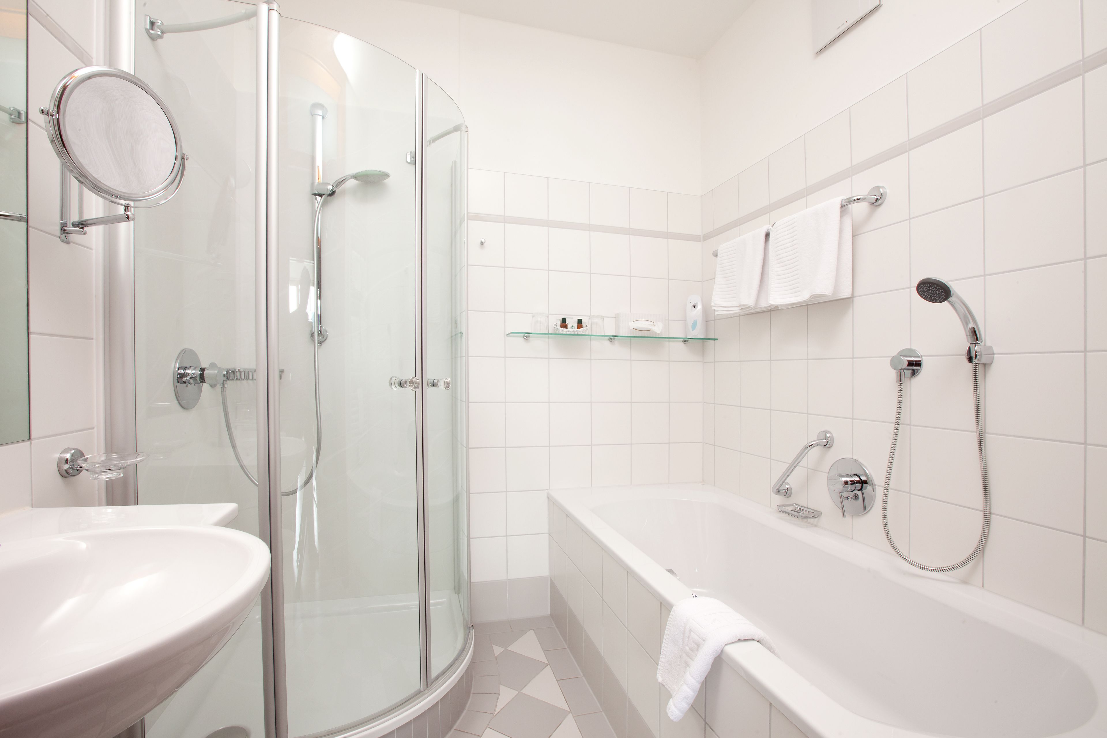 A modern bathroom with a glass-enclosed shower, a freestanding bathtub, and a sink.