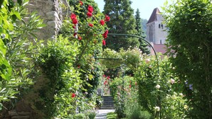 A garden pathway with flowering plants and a stone wall. - Richard Löwenherz (Durnstein)