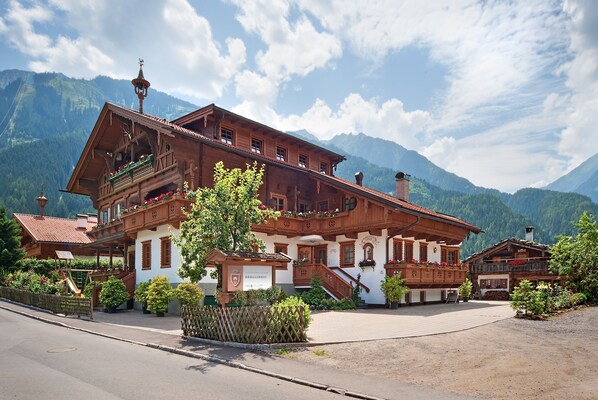 Ein traditionelles Holzgebäude mit Balkonen, einem Schild und einer Treppe, die zu den oberen Stockwerken führt.