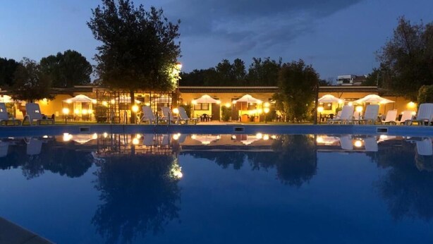 A poolside area with lounge chairs and a building with outdoor seating. - KoKo Hotel Milano Marittima (Ravenna)