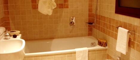 A bathroom with a bathtub, two sinks, a scale, and a toilet.