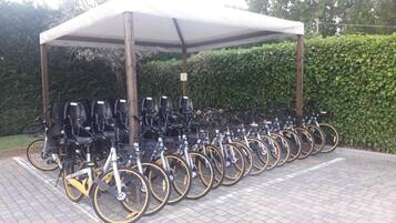 Un área de estacionamiento para bicicletas cubierta con varias bicicletas.