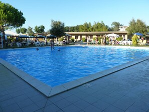A swimming pool with tiled edges, surrounded by outdoor seating and umbrellas. - KoKo Hotel Milano Marittima (Ravenna)