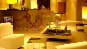 A modern hotel lobby with a reception desk, seating area, and a decorative wall. - KoKo Hotel Milano Marittima (Ravenna)