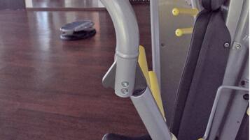 A gym with exercise equipment, including a leg press machine and a bench.