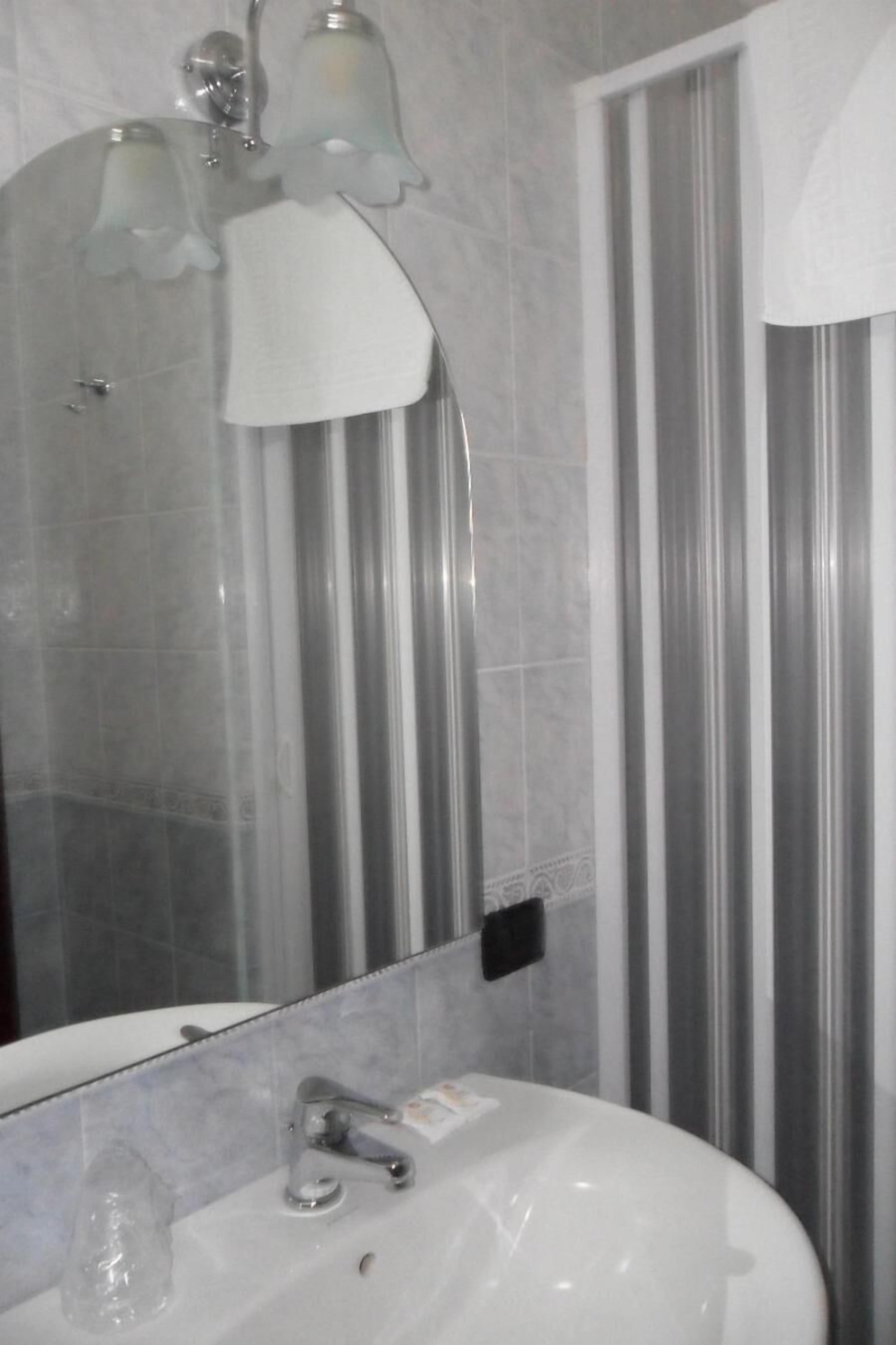 A bathroom with a white sink, a mirror, and a shower curtain.
