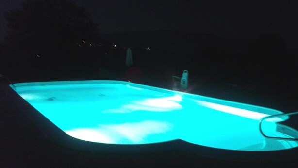 A swimming pool at night with a blue light. - Country House L'Ippocastano (Altavilla Silentina)