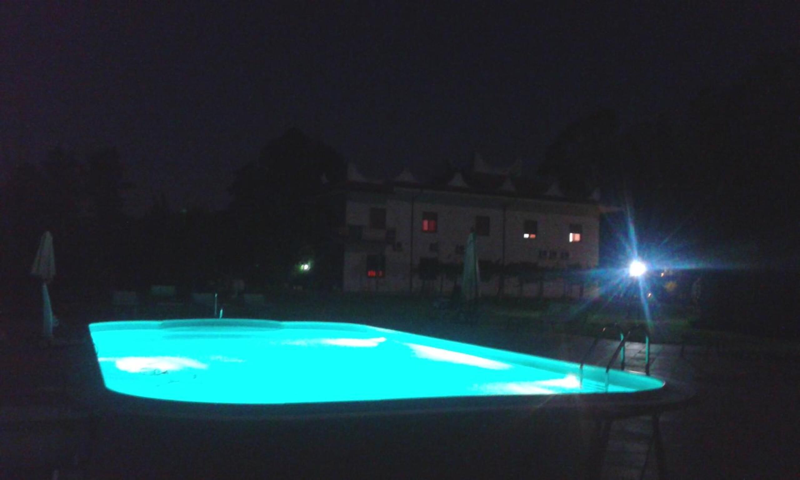 A swimming pool at night with a blue light.