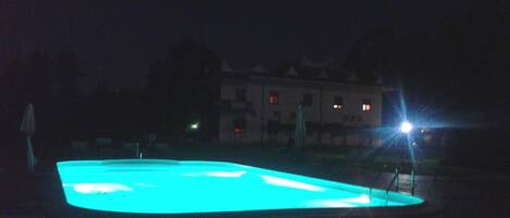 A swimming pool at night with a blue light.