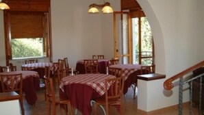 A dining area with wooden tables and chairs, covered with red tablecloths. There are hanging lights above the tables. - Country House L'Ippocastano (Altavilla Silentina)