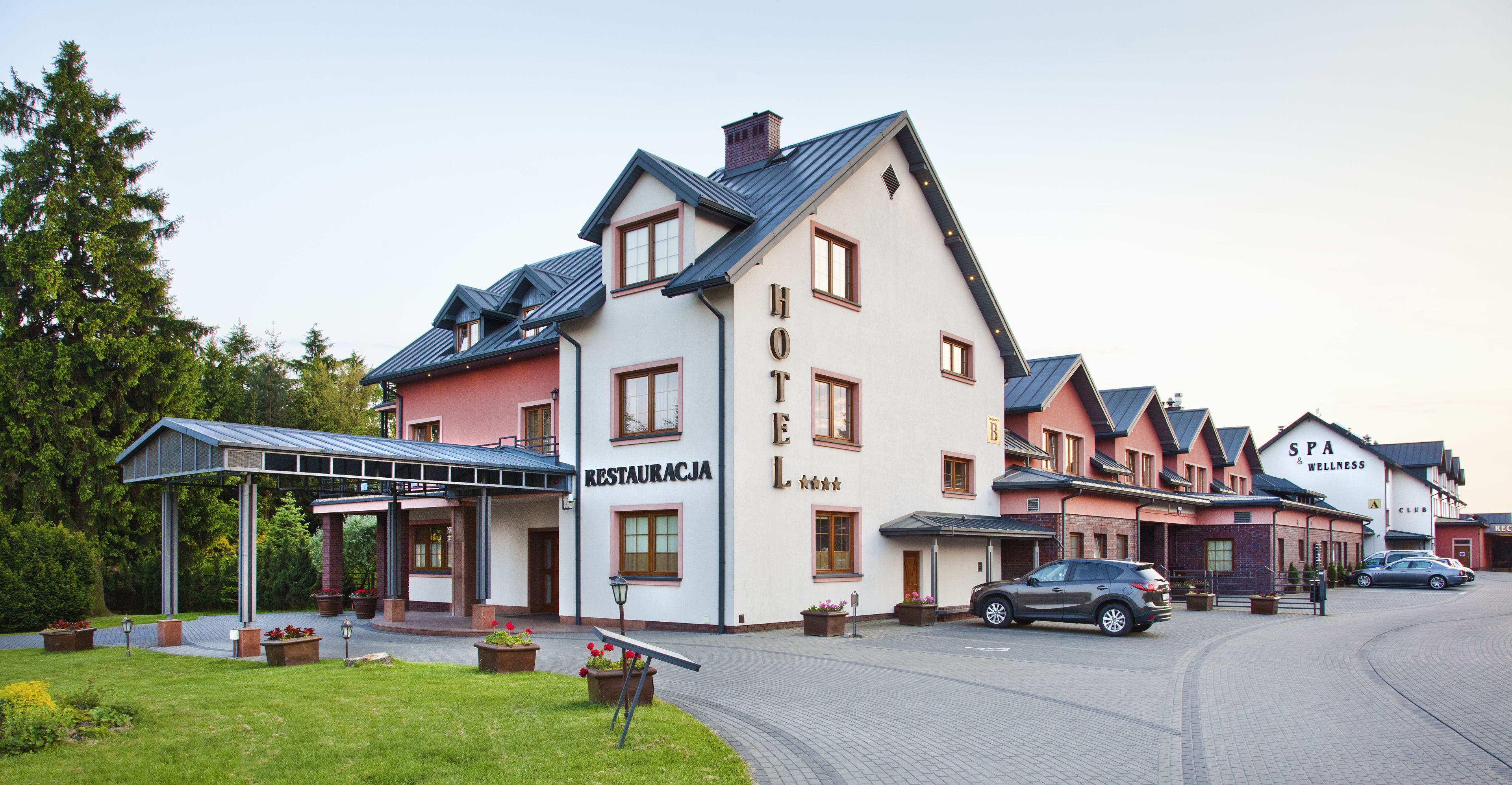 A hotel with a restaurant and spa named "RESTAURACJA" and "SPA & WELLNESS".