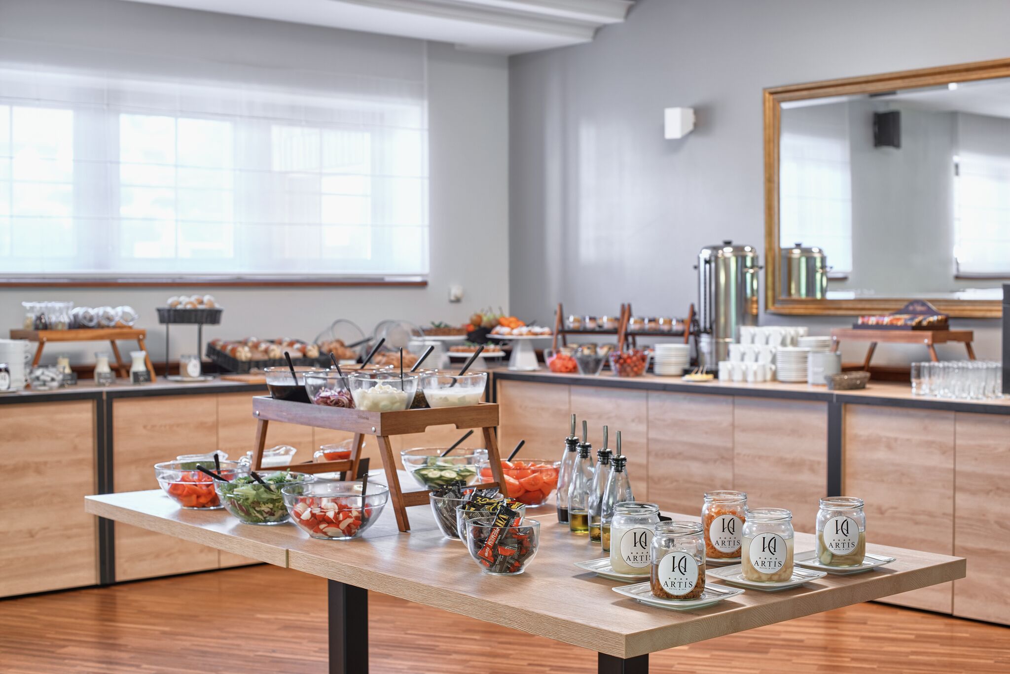 A buffet setup with various food items and condiments on a wooden table.
