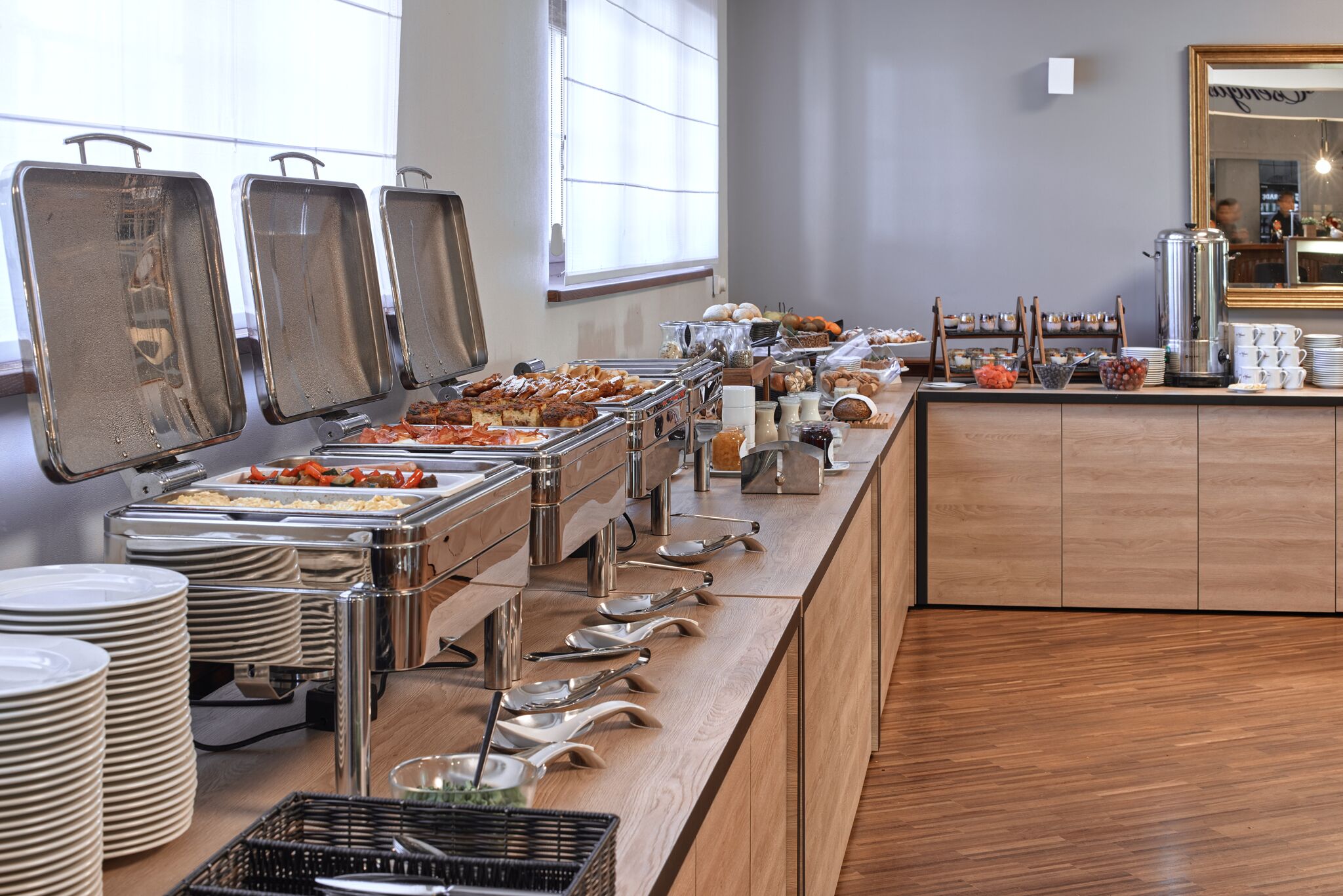 A buffet setup with various food items and utensils.