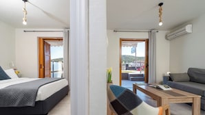 Una camera d'albergo con un letto, un divano, un tavolino da caffè e vista all'esterno.