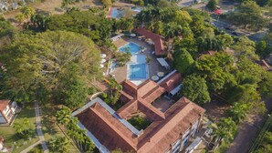 An aerial view of a residential property with a swimming pool, multiple rooms, and surrounding greenery. - Hotel Girardot Resort by On Vacation (Ricaurte)