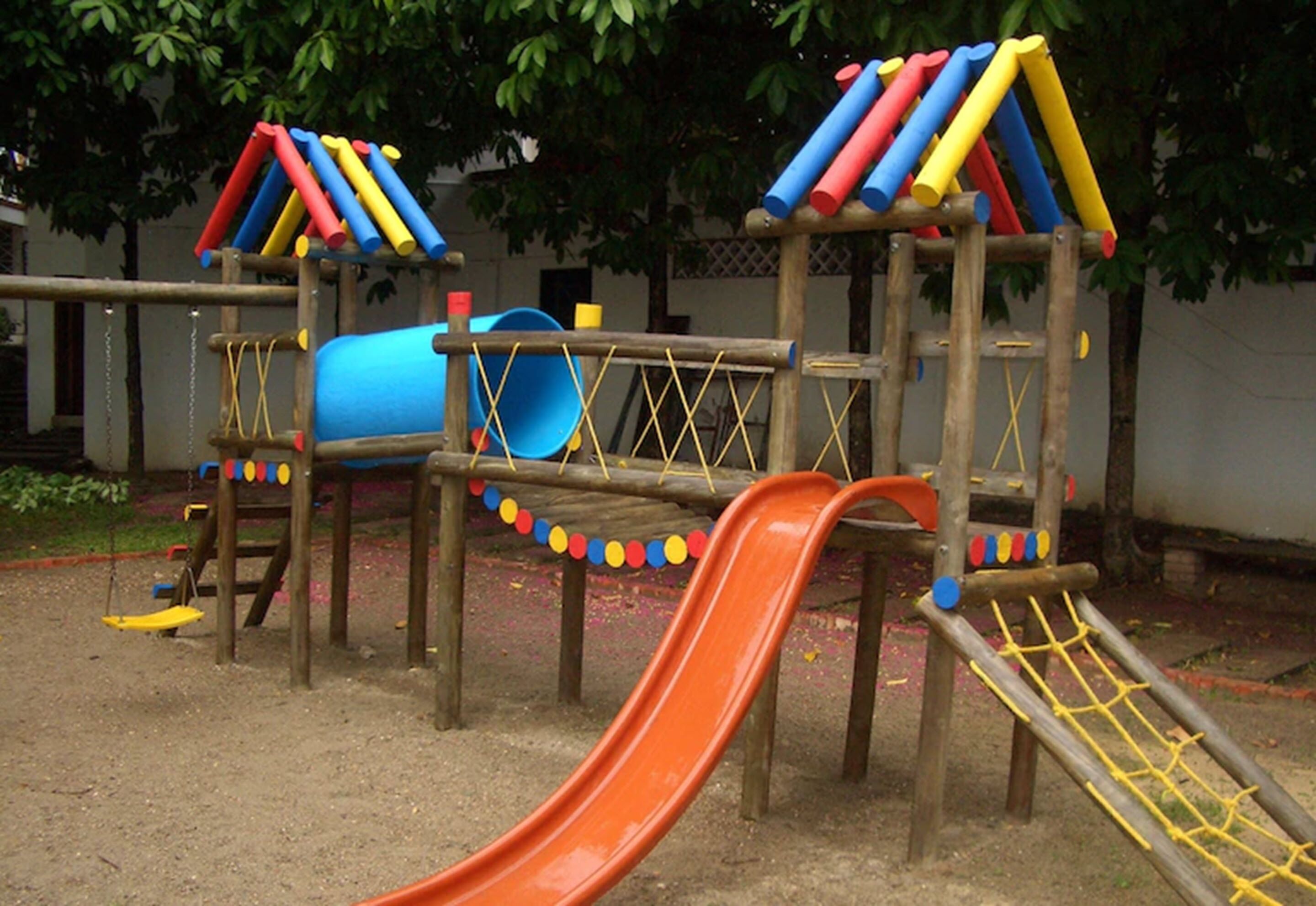 A playground with a slide, climbing structures, and a swing set.