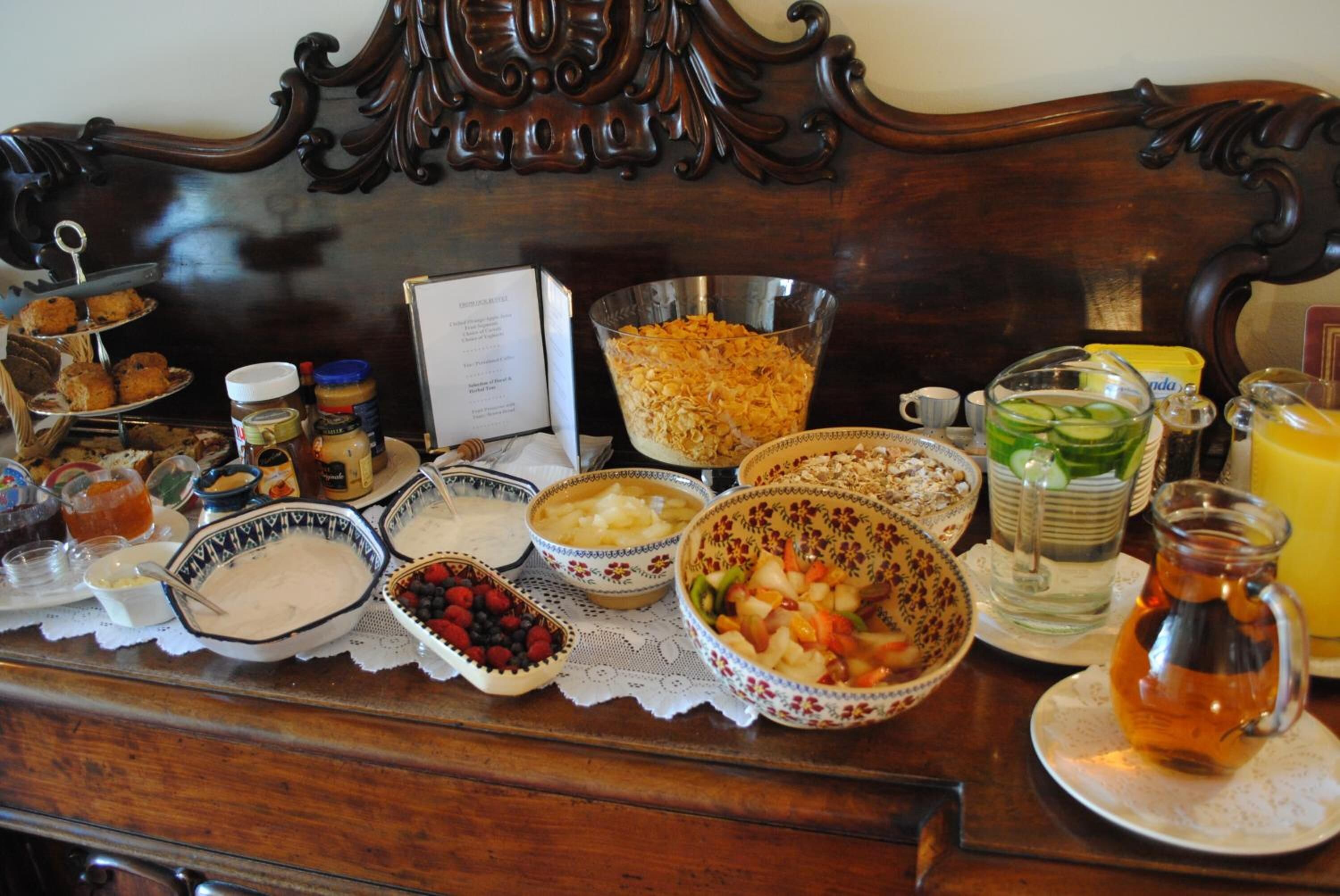 A breakfast buffet with various dishes and beverages on a wooden table.