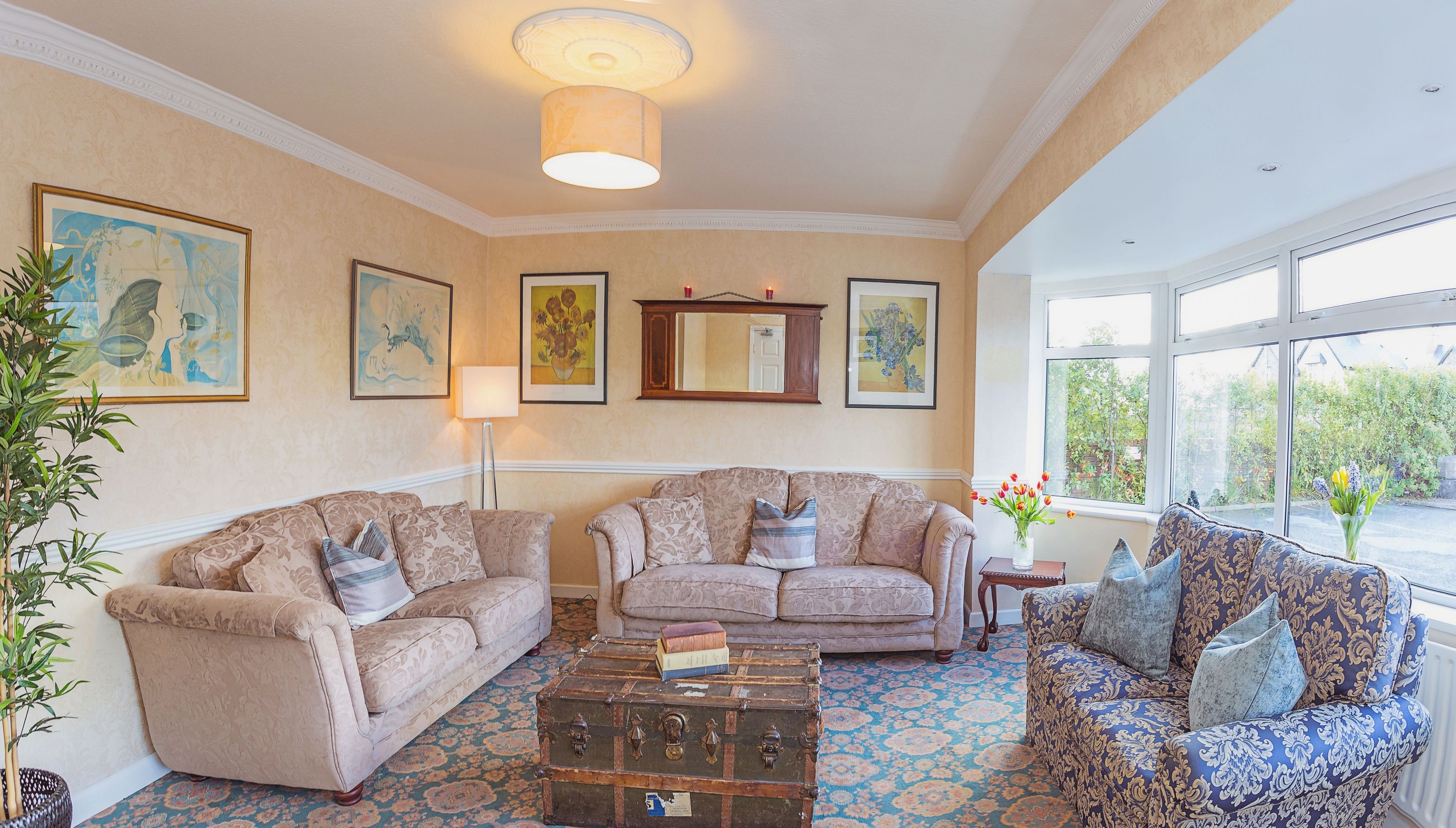 A spacious living room with two sofas, a coffee table, and a large window providing a view of the outdoors.