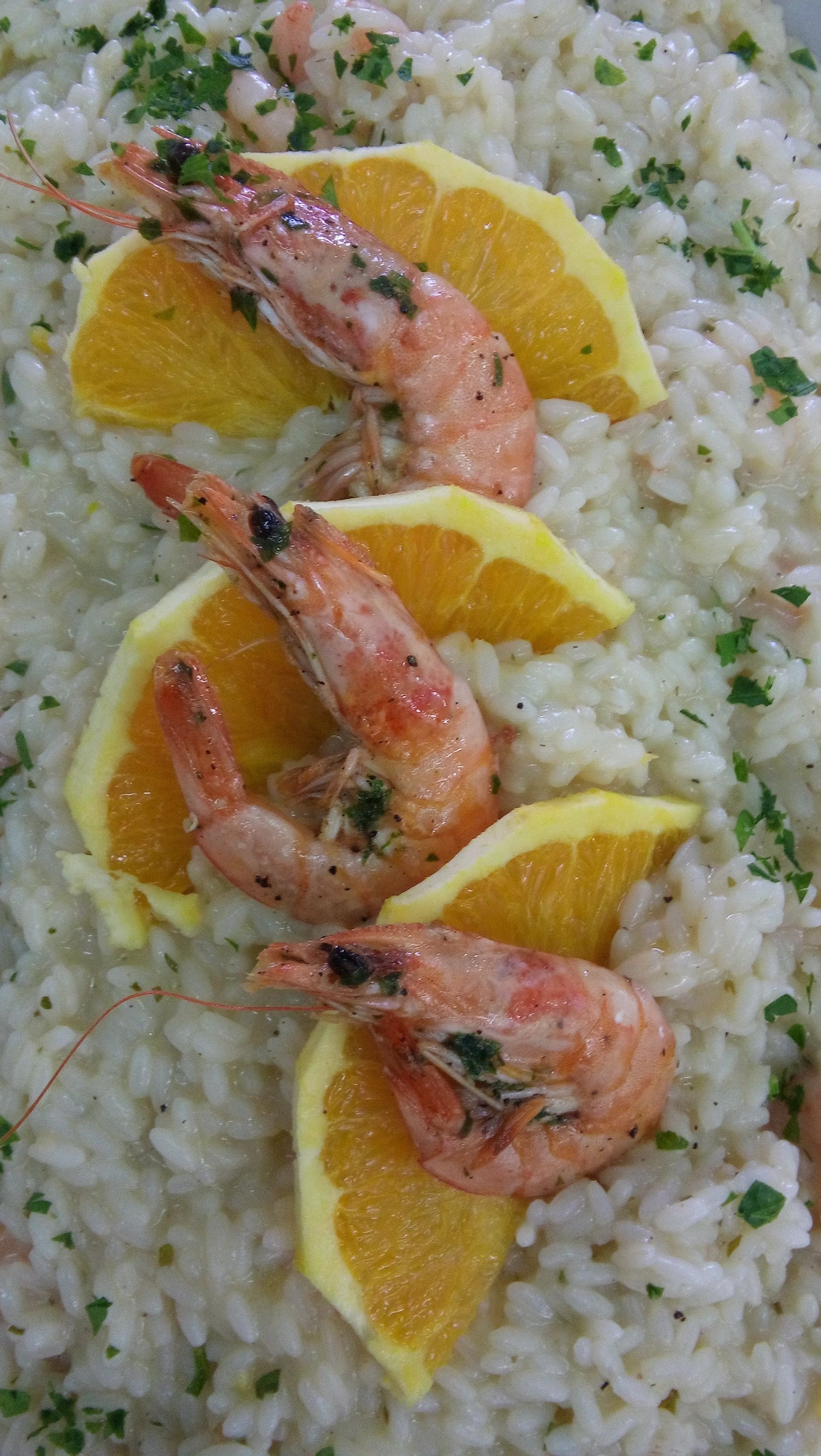 Une assiette de crevettes et de riz, garnie de tranches de citron.