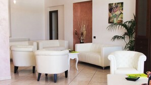 Amplia sala de estar con un sofá blanco, una mesa de centro y una planta en maceta.