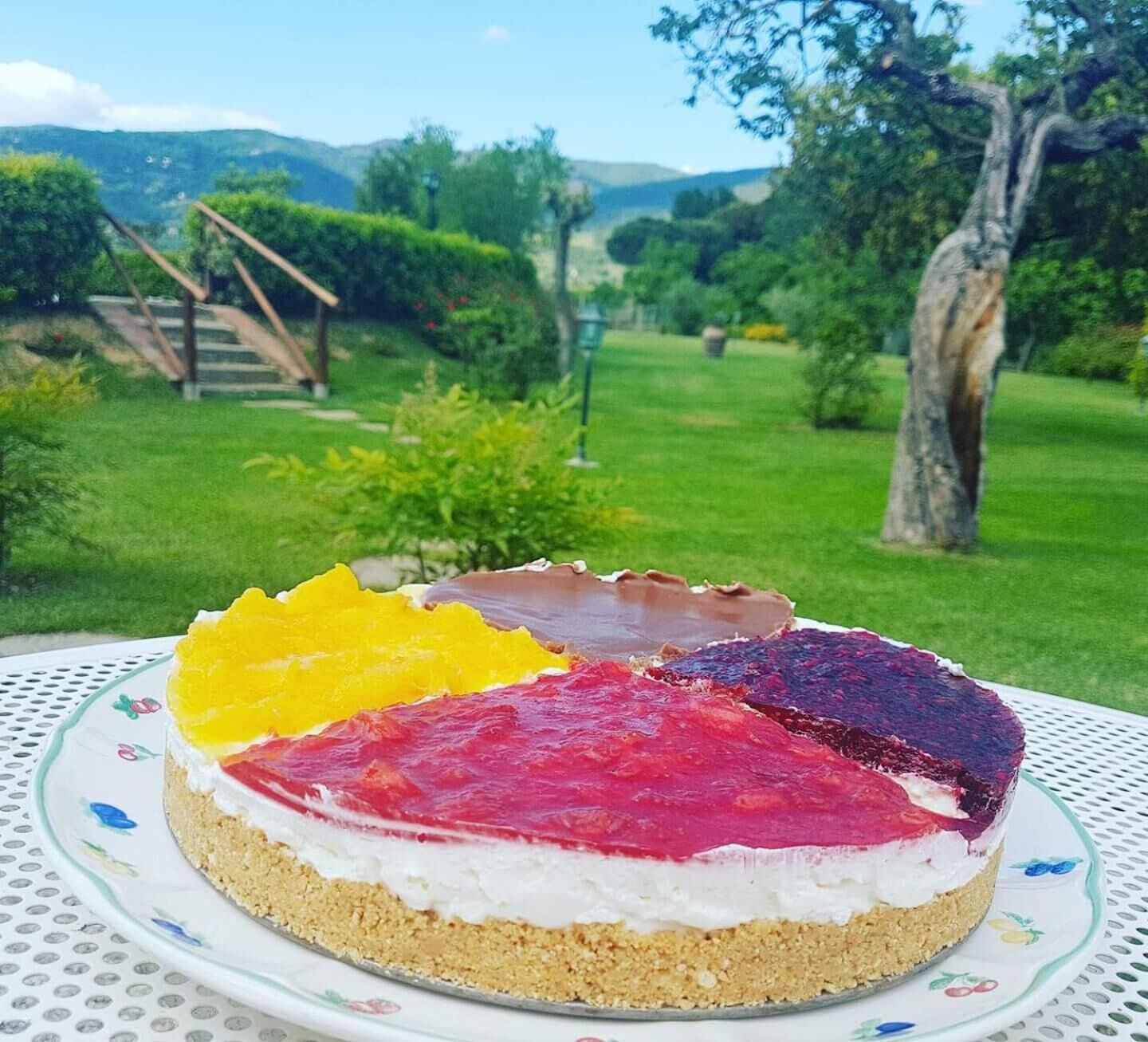 Ein gestreiftes Dessert auf einem Teller, im Hintergrund ein Garten.