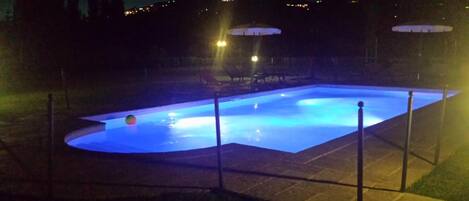 Una piscina iluminada con luz azul durante la noche.