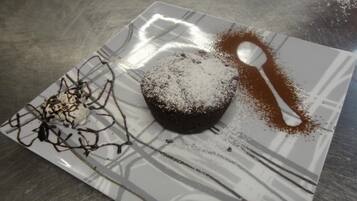 Een dessert op een bord met poedersuiker en chocoladesiroop.