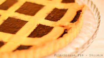 Tarta de manzana con cubierta enrejada sobre un plato de vidrio.