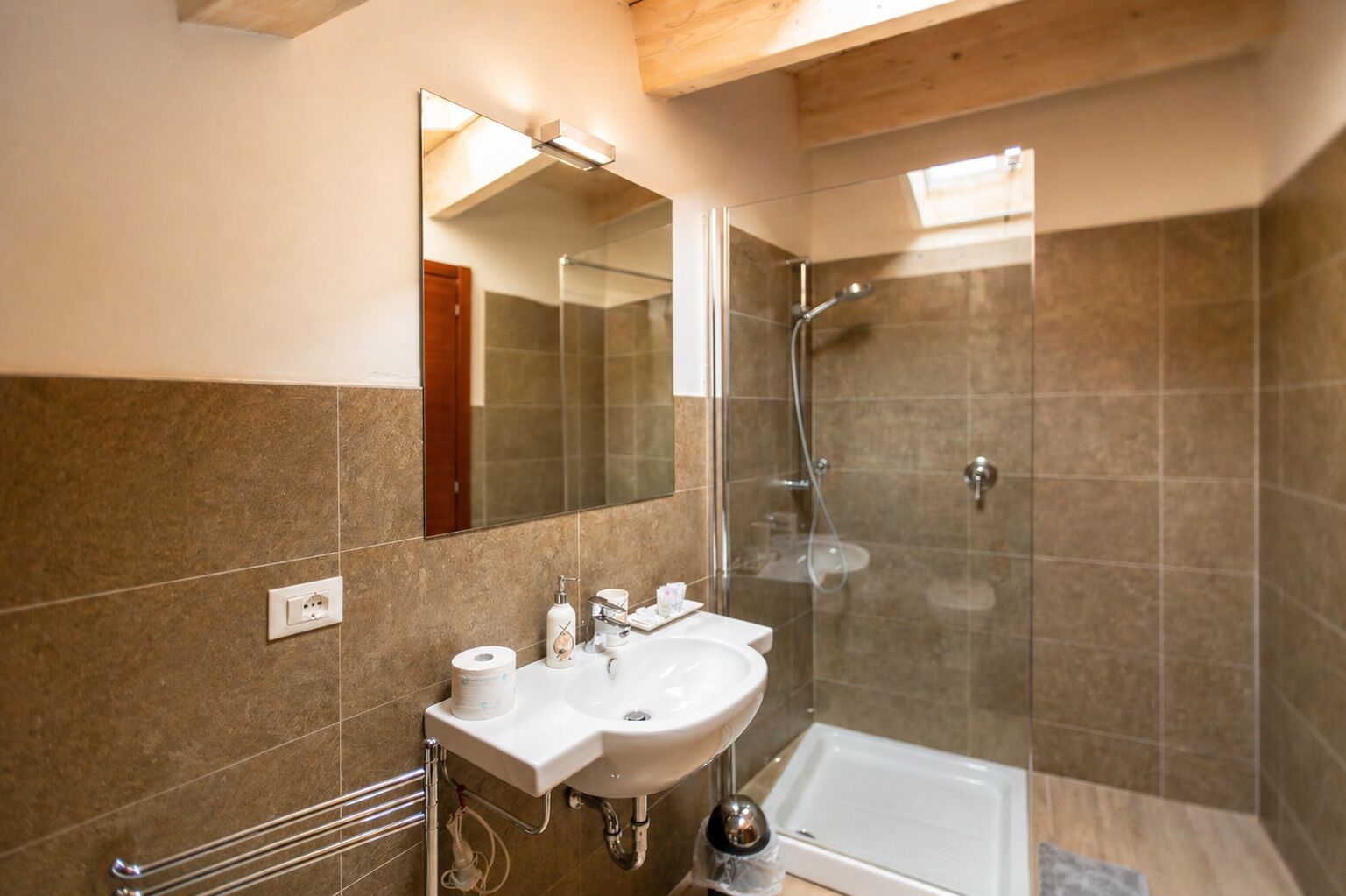 A modern bathroom with a glass shower enclosure, a white sink, and a bathtub.