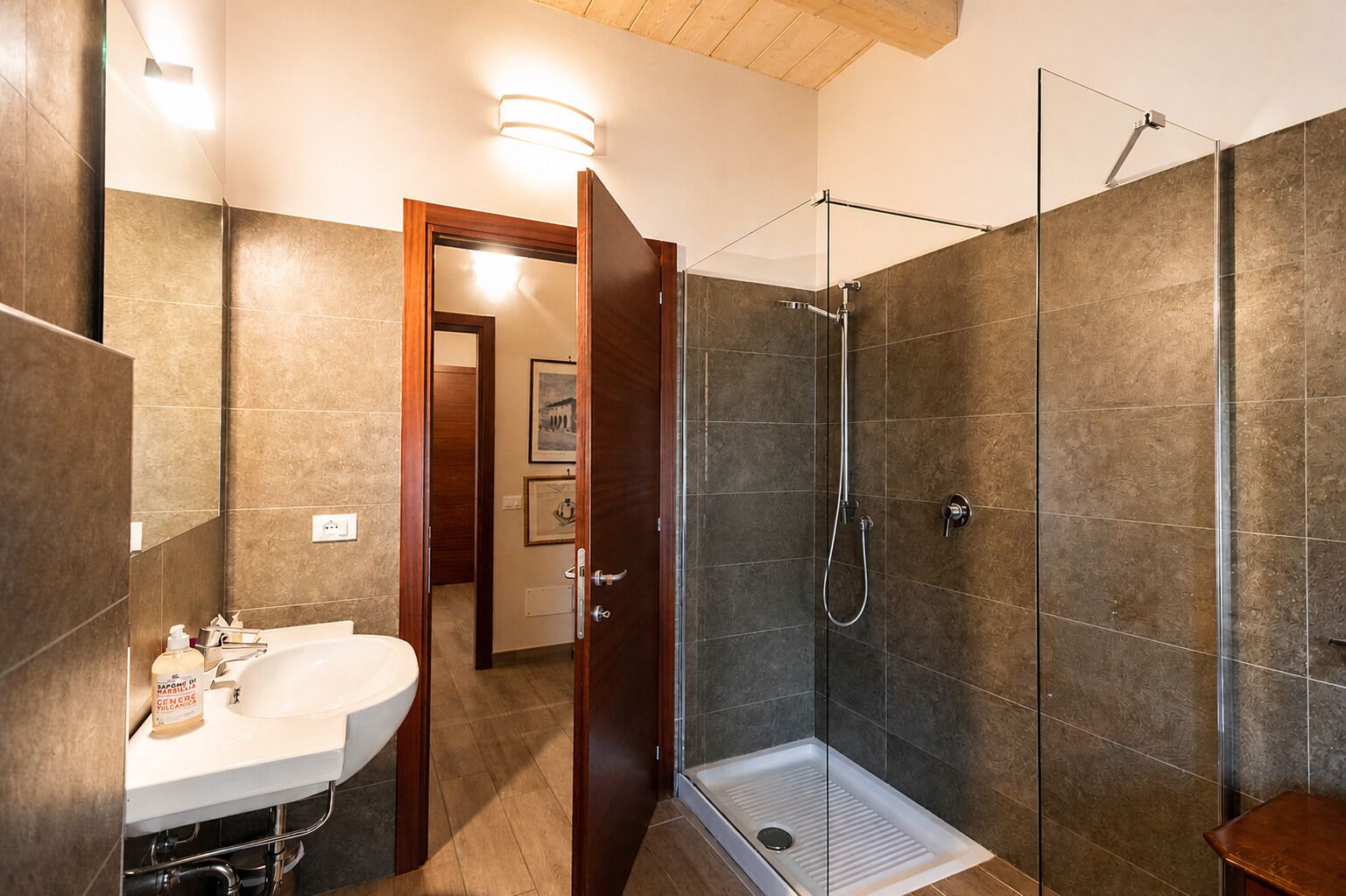 A bathroom with a shower, sink, and toilet.