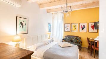 Une chambre à coucher avec un lit, une table en bois, un canapé et un téléviseur.