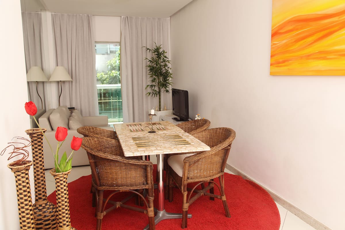 A dining area with a table, chairs, and a red carpet.