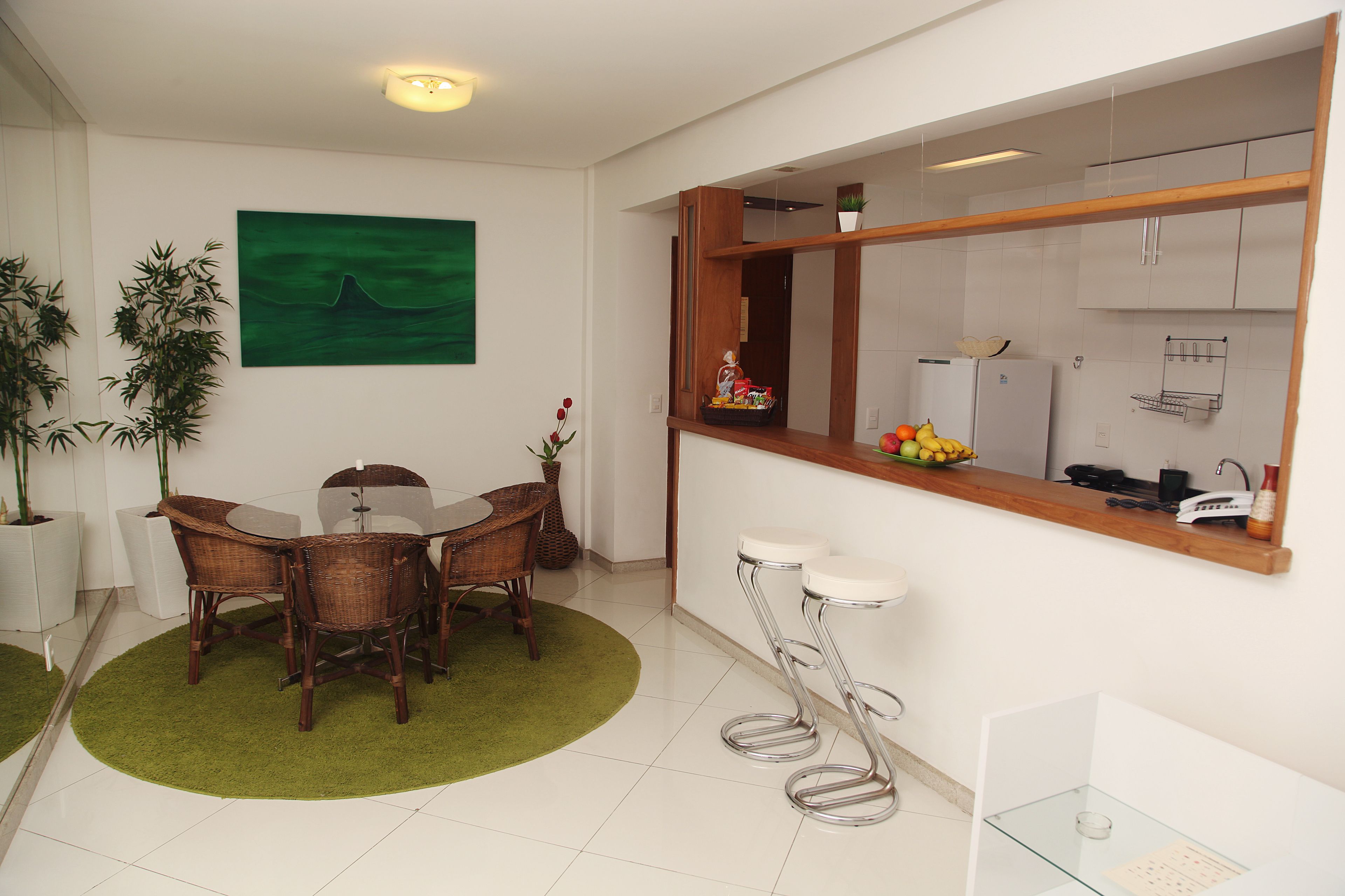 A modern kitchen with white cabinets, a wooden countertop, and a built-in refrigerator.