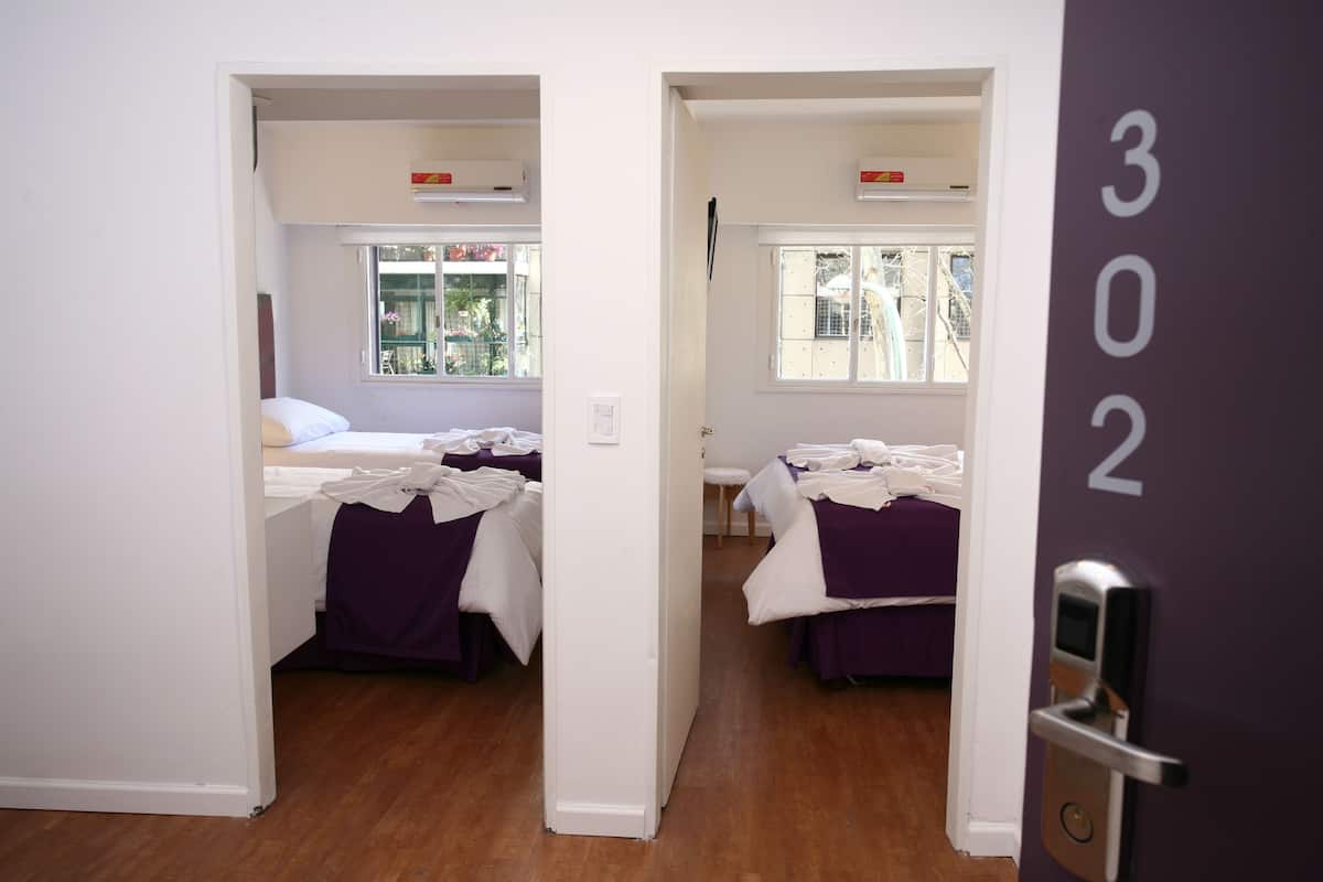 Una habitación de hotel con dos camas, una ventana y una puerta con un número.